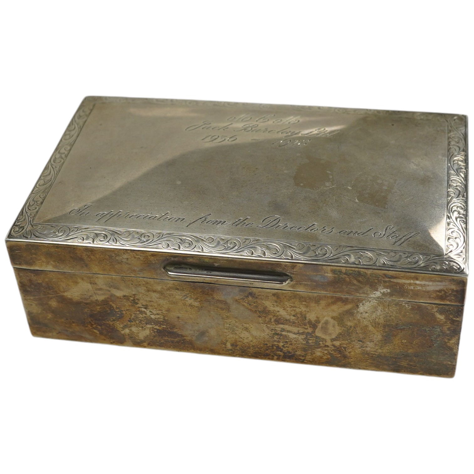 An Elizabeth II silver mounted rectangular cigarette box, with engraved inscription, C.S. Green & Co, Birmingham, 1975, 16.4cm. Condition - poor to fair